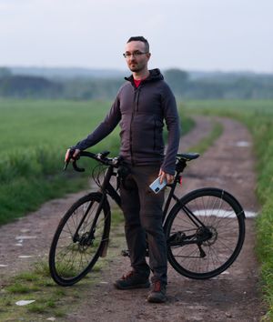 Self-portrait photo of Aleksandr Kadykov with a bike on a road
