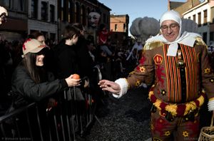 A dancing Gille offers an orange to a young lady