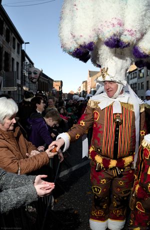 A Gille offers an orange to an eldery woman