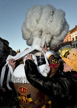 A lady helps a Gille to put on a traditional hat