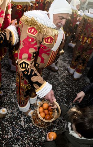 A Gille offers to a boy to take oranges from his basket